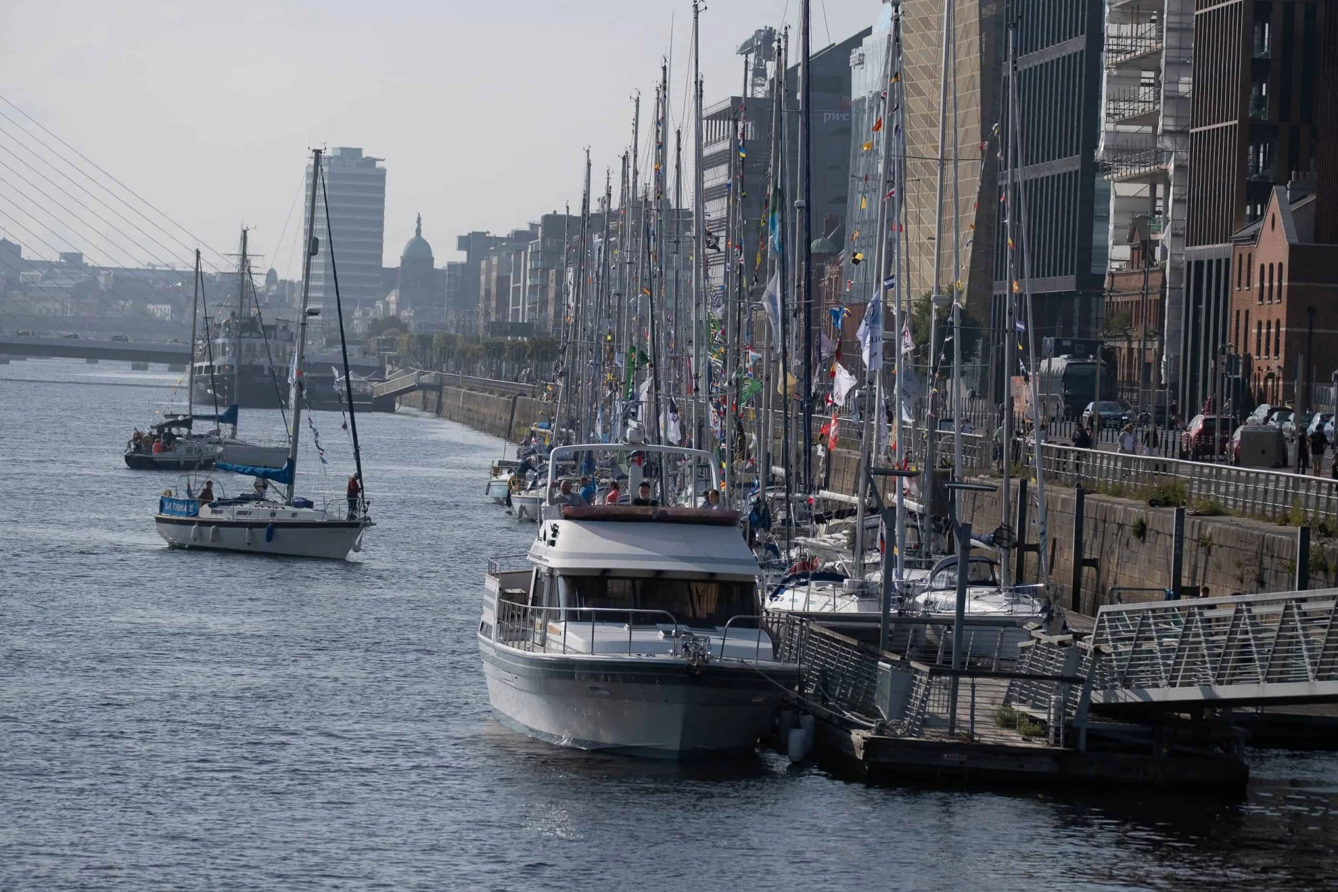 Motor boat and sailing boats moored on a pontoon in the river Liffey