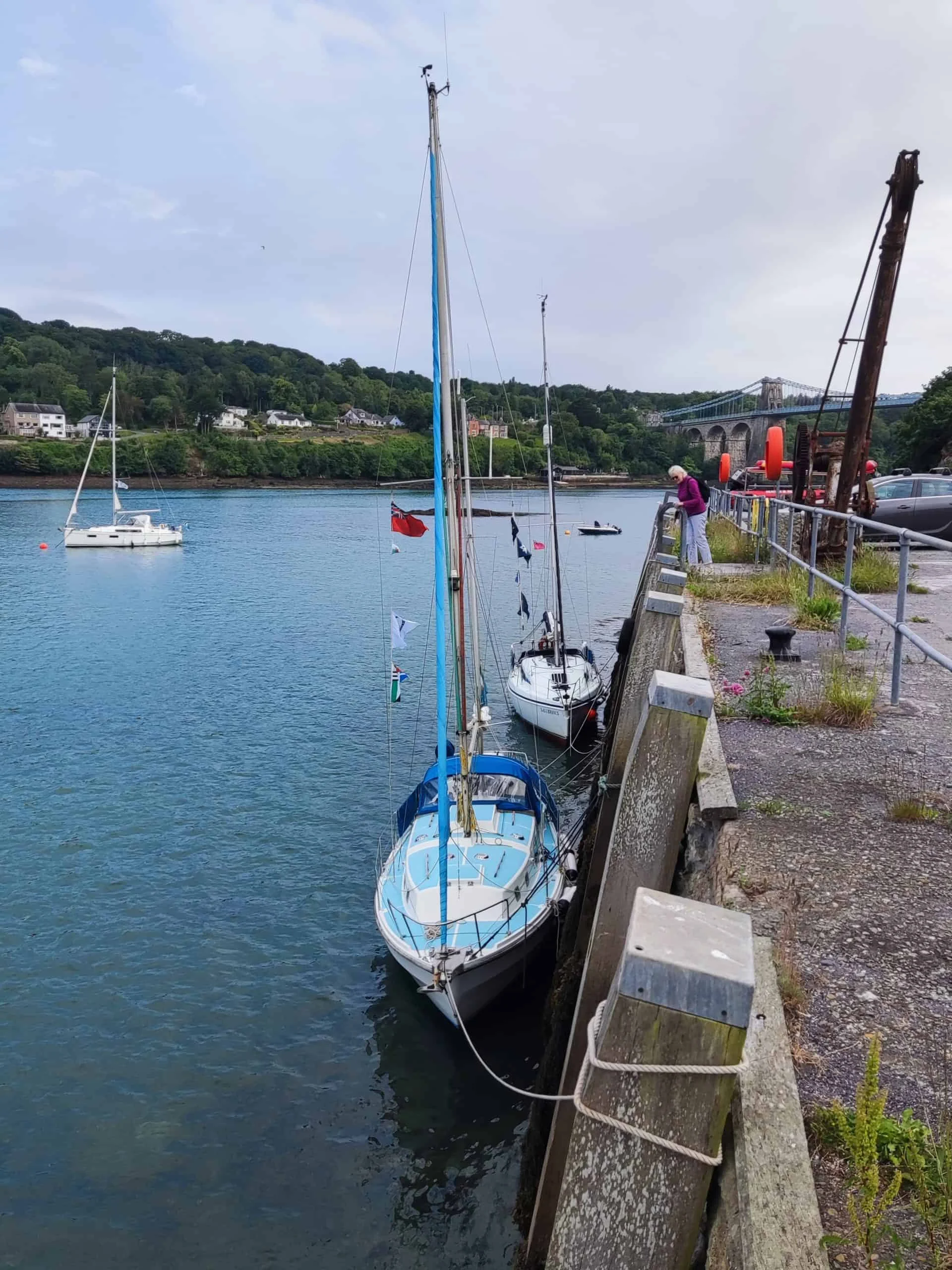 Two sailing yachts drying out alongside a wall in Menai Bridge