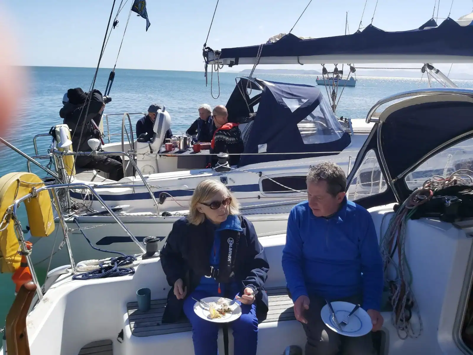Sailors enjoying lunch in sunshine at anchor off Lambay Island.