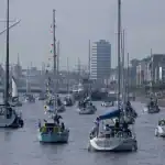 Yachts without sails motoring on the Liffey towards the Samuel Becket bridge