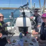 A group of sailors in the cockpit of a yacht at lunch time